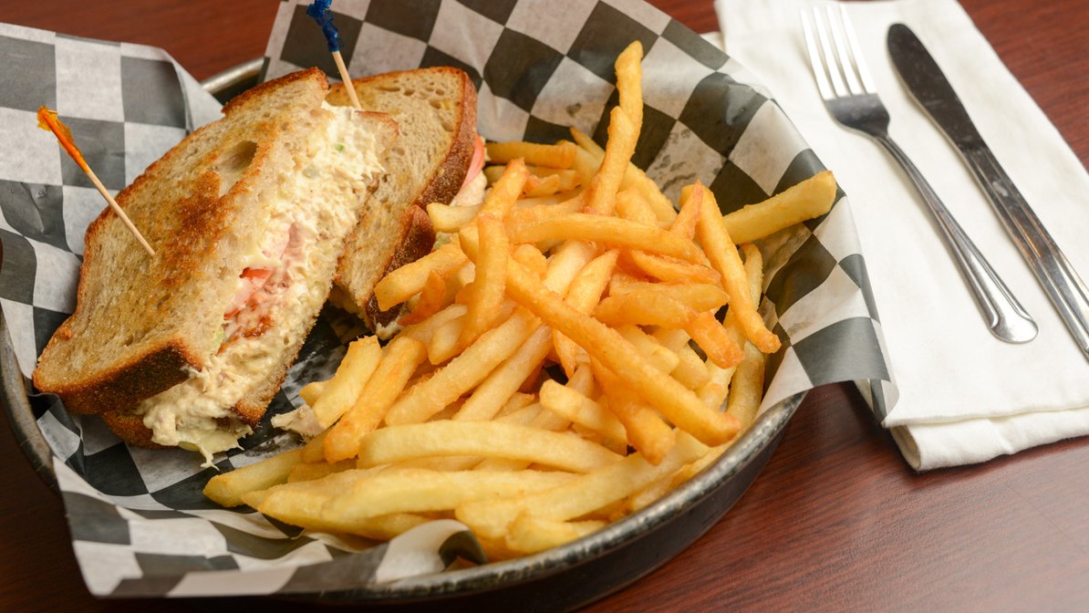 A basket of french fries and a sandwich.