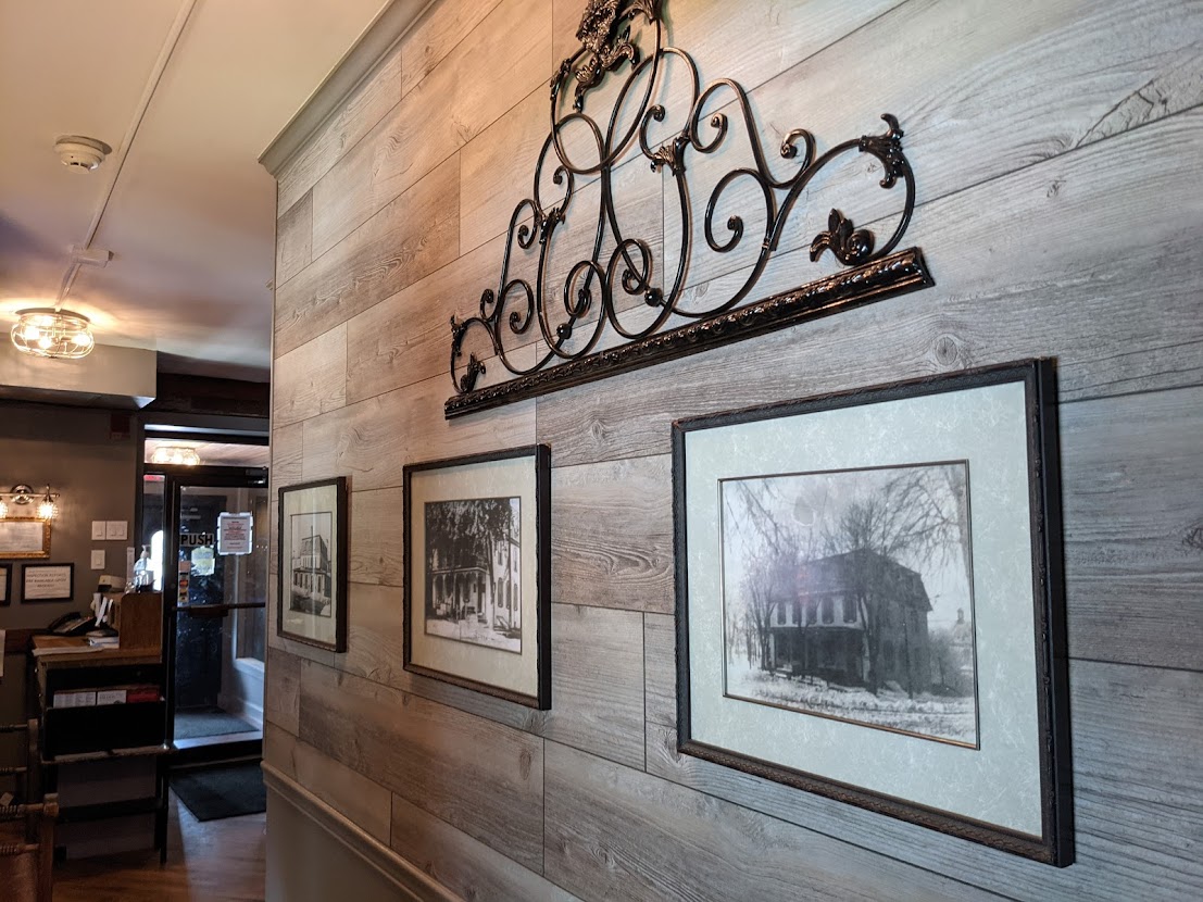 A hallway with framed pictures on the wall.