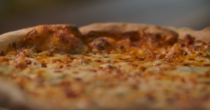 A close up of a pizza with cheese on it.